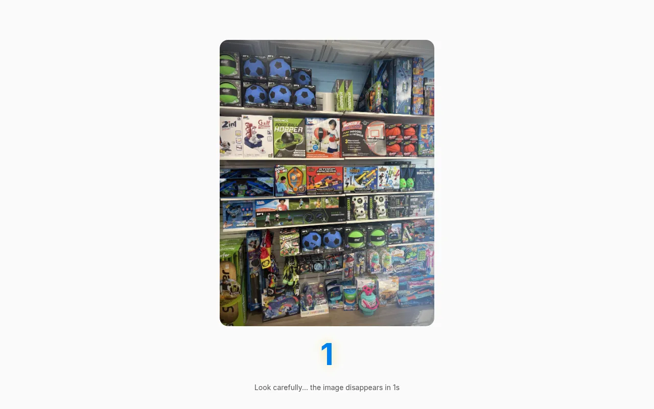 Blinkle's daily photo for 27 October 2026: toy shop shelves with soccer balls and boxed games, shown with a one-second countdown before it disappears