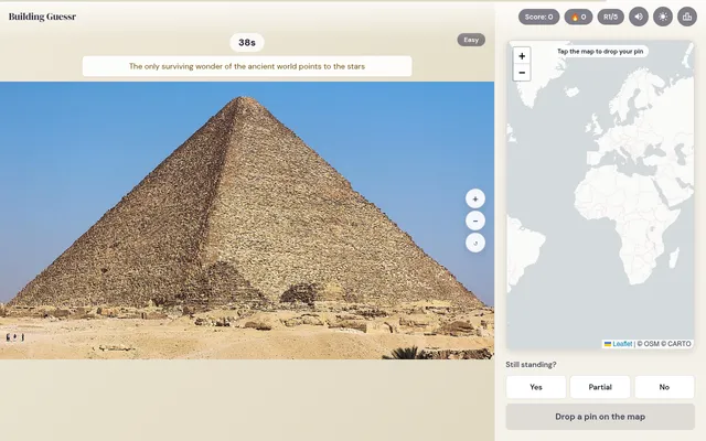 Building Guessr round on desktop: a photo of the Great Pyramid of Giza with a hint line and timer, beside a world map to drop a pin and Yes, Partial, No buttons for Still standing