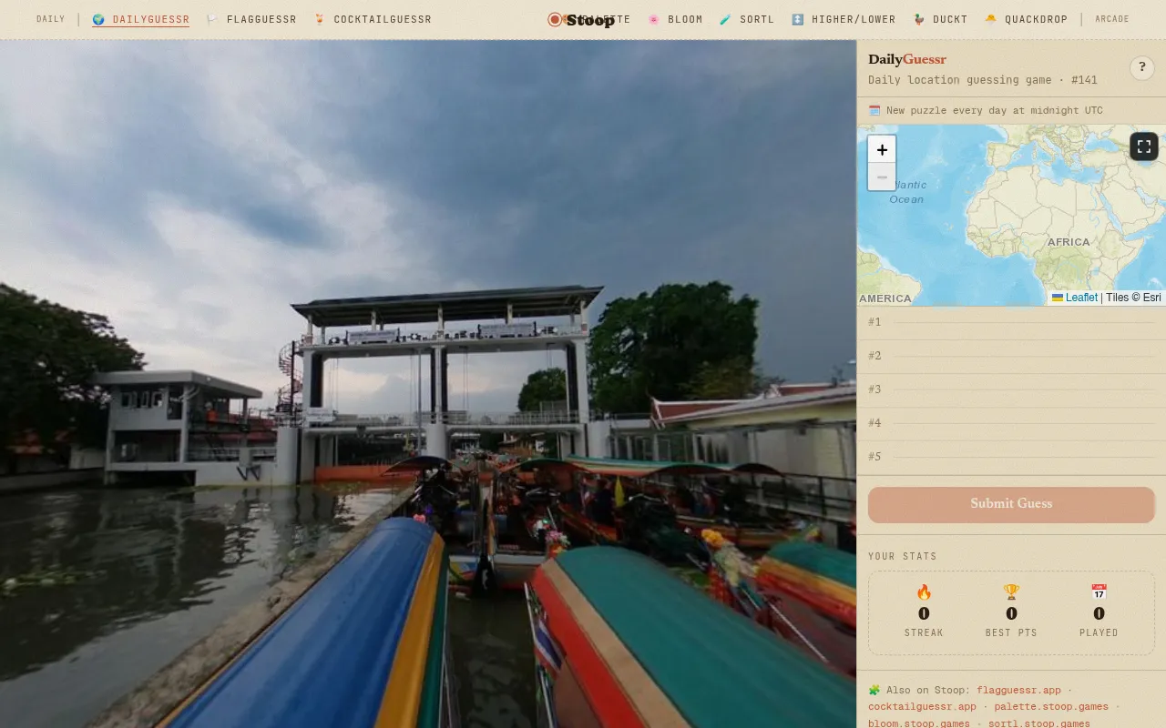 DailyGuessr #141: a street-level panorama of colourful long-tail boats on a canal by a sluice gate, beside the world map for placing pins and five empty guess rows
