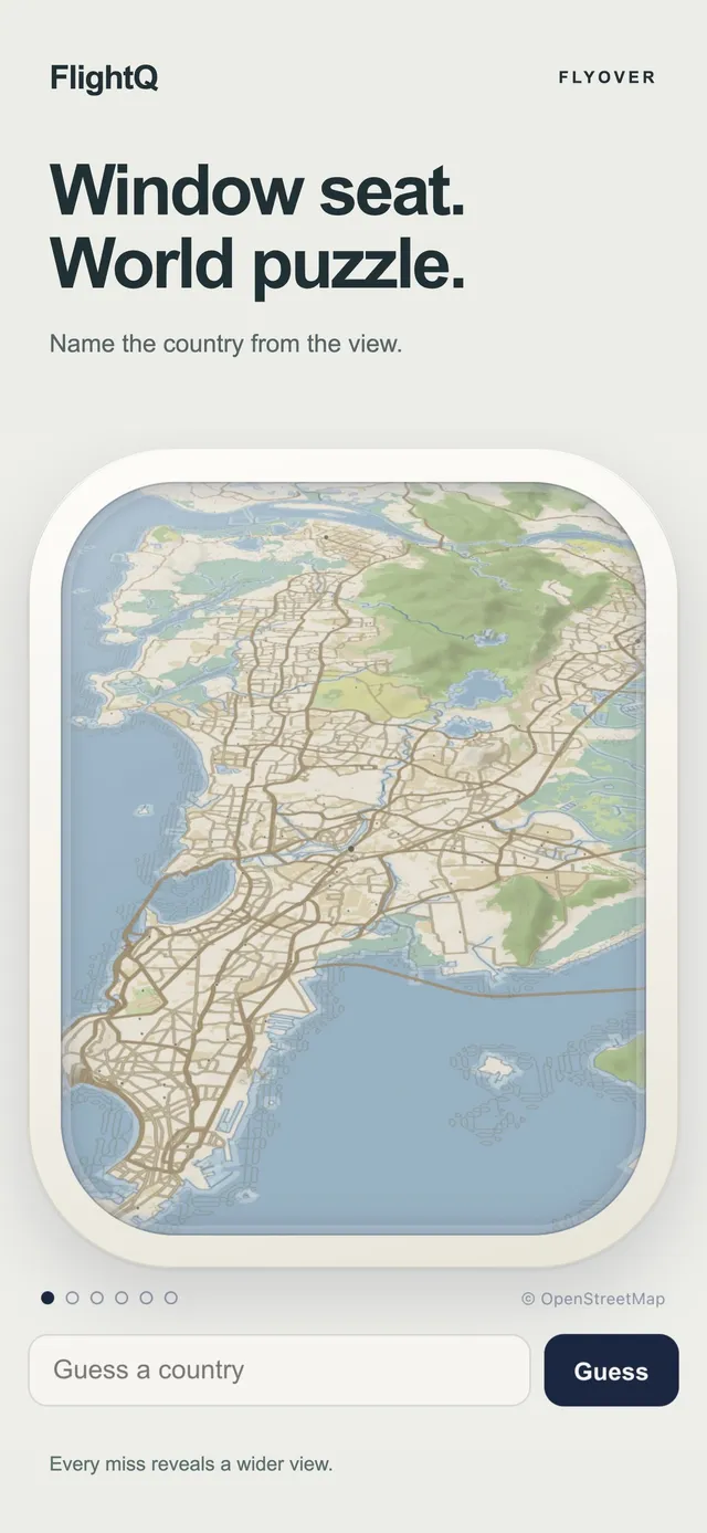 Flyover on the FlightQ app: Window seat. World puzzle. An unlabelled map of a coastal city seen through a plane window, above a Guess a country box