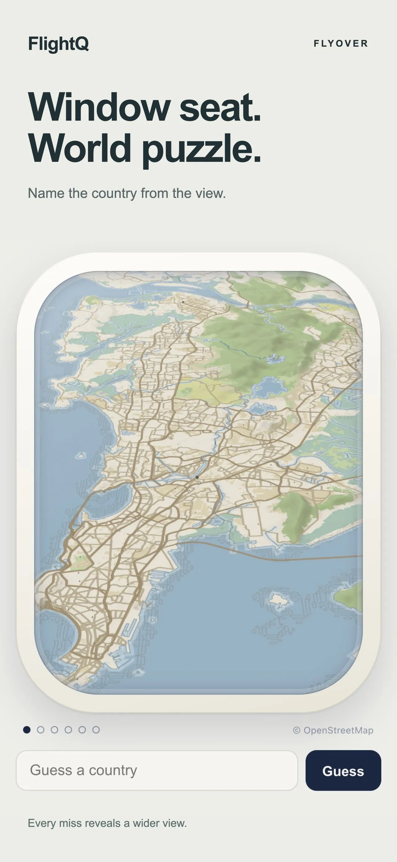 Flyover on the FlightQ app: Window seat. World puzzle. An unlabelled map of a coastal city seen through a plane window, above a Guess a country box