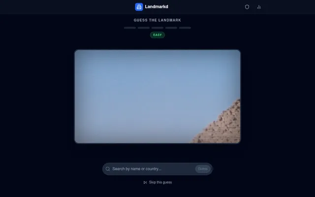 Landmarkd Guess the Landmark screen: an Easy badge and five empty guess bars above a zoomed-in photo showing sky and the stepped edge of a stone pyramid, with a Search by name or country box, a Guess