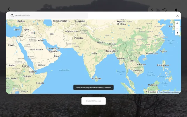 Location Guesser's guess map: a world map centred on India with a location search box, zoom buttons and a Submit Guess button over the dimmed daily video