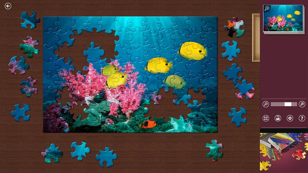 A half-finished Microsoft Jigsaw puzzle of tropical fish and pink coral, with loose pieces around the board and a preview in the corner