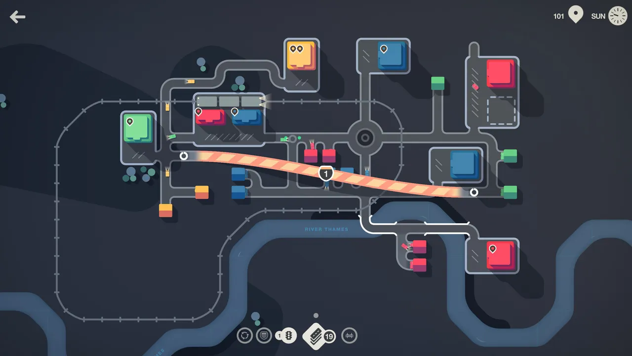 Mini Motorways gameplay: a dark city map with coloured houses and destinations linked by grey roads, a roundabout and a highlighted motorway crossing a river