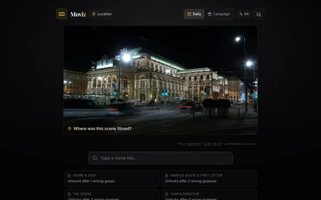 Moviz daily Location puzzle: a night photo of a large lit-up building at a tram crossing, captioned 'Where was this scene filmed?', with a movie title box and locked clues below