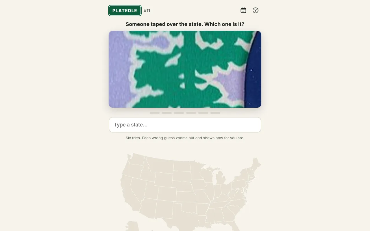 Platedle plate #11 at the start of a round: a zoomed-in close-up of a green and lilac plate detail above the state guess box and a blank US map