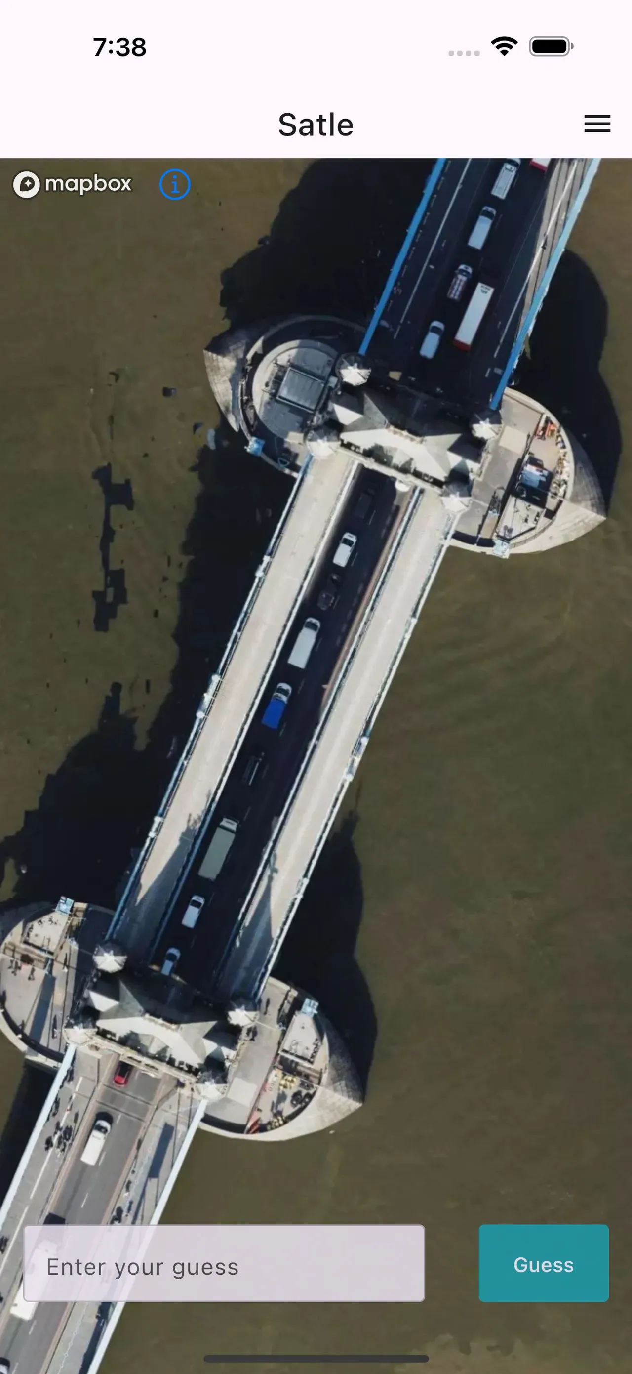 Satle on iPhone: a close-up satellite view of a bridge across a river, with the Enter your guess box