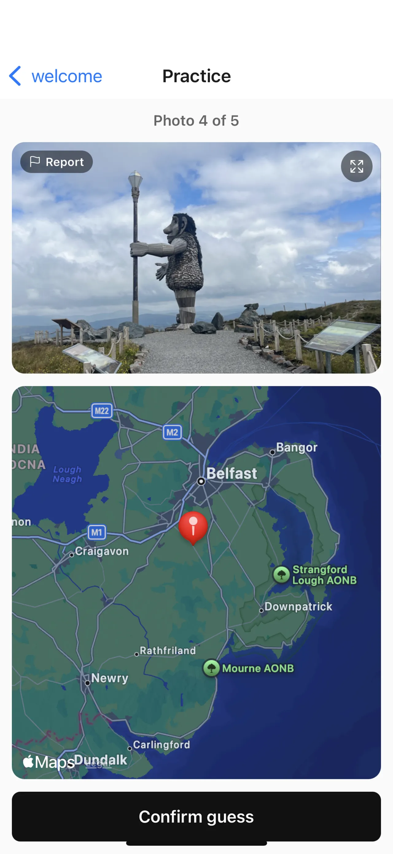 Snaptrip round: a travel photo of a large troll sculpture on a hilltop above a map of Northern Ireland with a red guess pin and a Confirm guess button