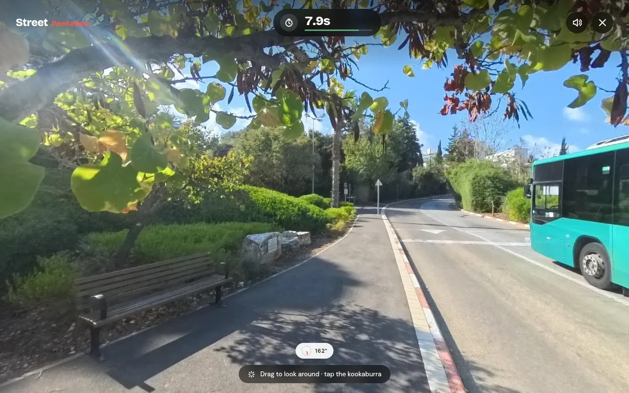 Street Peekaboo in play on a desktop: a 360-degree street in Haifa with trees, a bench and a green bus, the ten-second timer at the top