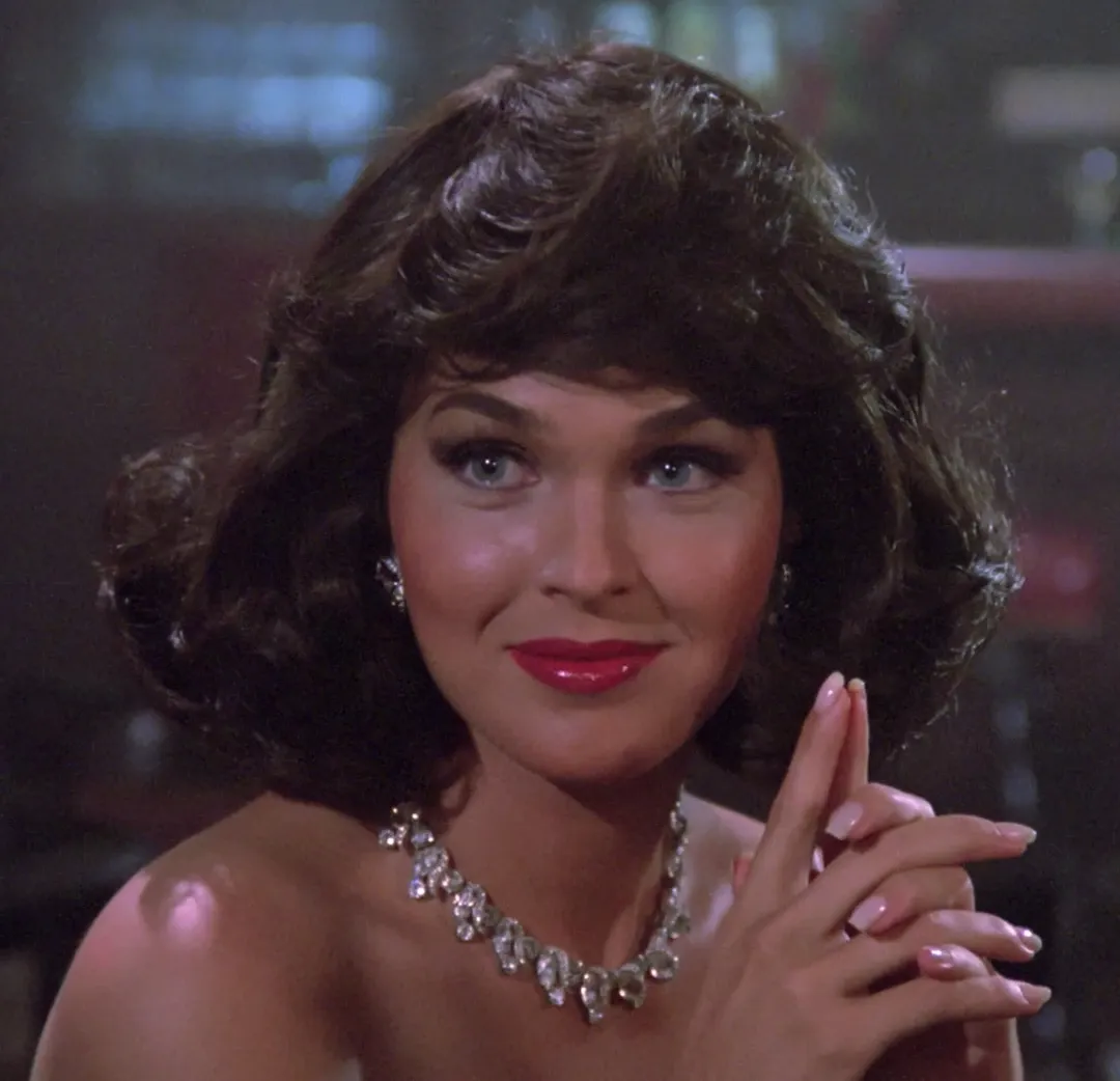 One of Trekdle's clue stills: Minuet, the holodeck character from The Next Generation, smiling in a dimly lit bar