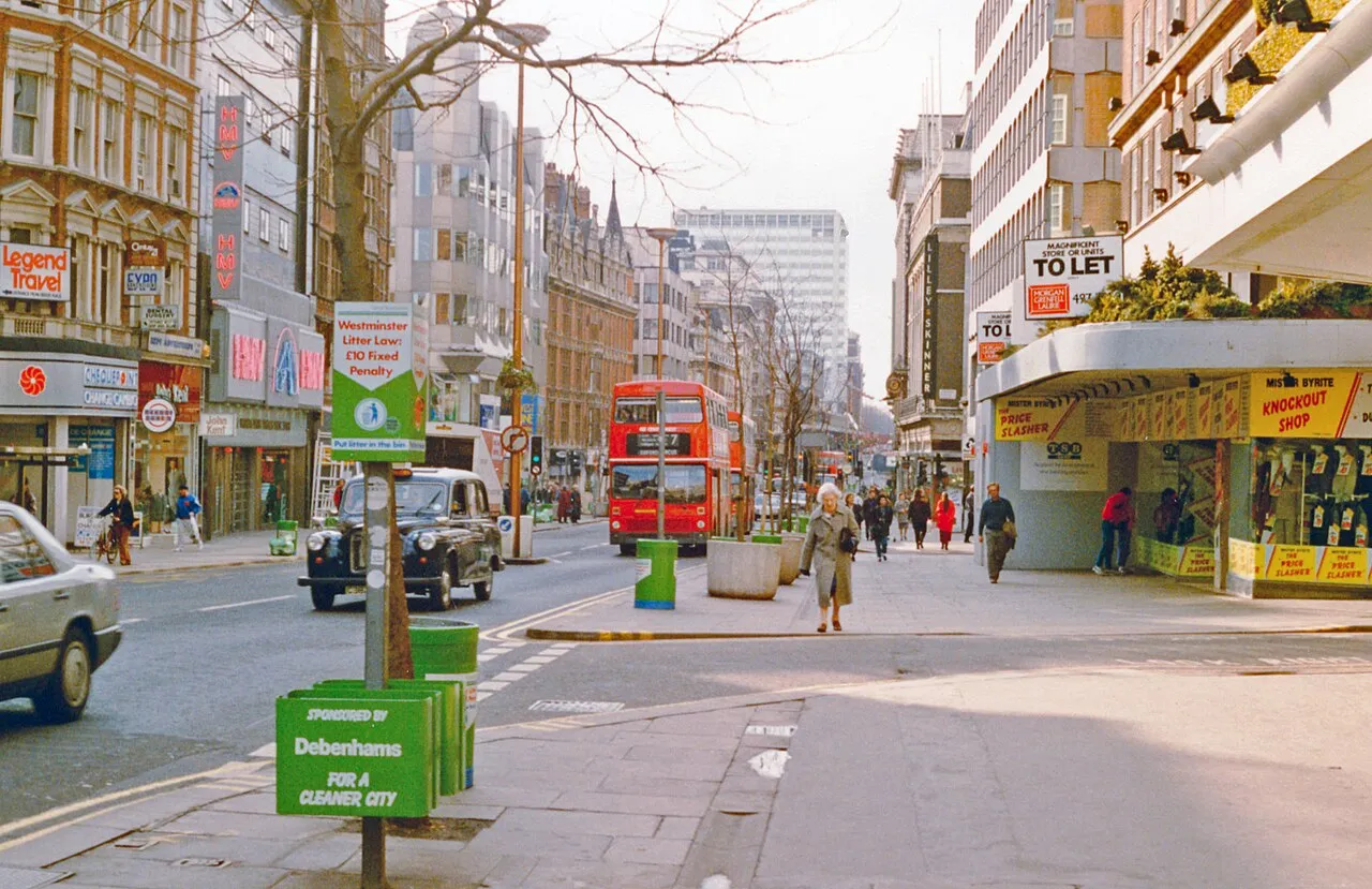 An older London street scene with a red double-decker bus and black cab, the example photo from WhenTaken's home page