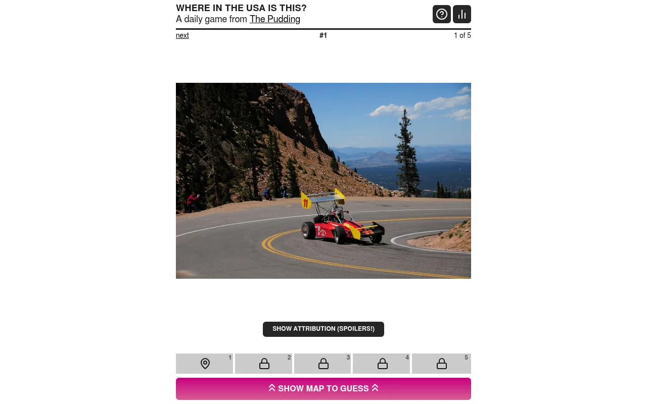 Where in the USA is this?: the first of five photos, a red race car on a mountain road, with five guess tiles and a Show map to guess button